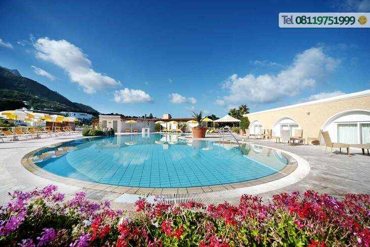 La piscina esterna a temperatura ambiente circondata da meravigliosi giardini fioriti.